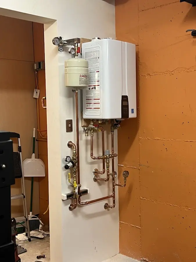 Plumbing technician inspecting water heater connections in Underwood-Petersville